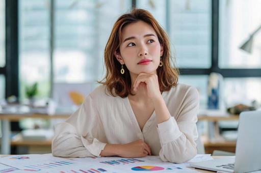 資料を見て悩むビジネス女性 資料を見て悩むビジネス女性の写真
