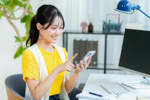 スマホを操作する若い女性 ビジネスウーマン,若い女性,笑顔の写真素材