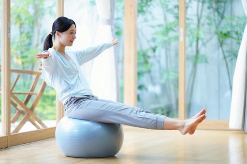 バランスボールに座りトレーニング中の女性 女性,バランスボール,座るの写真素材