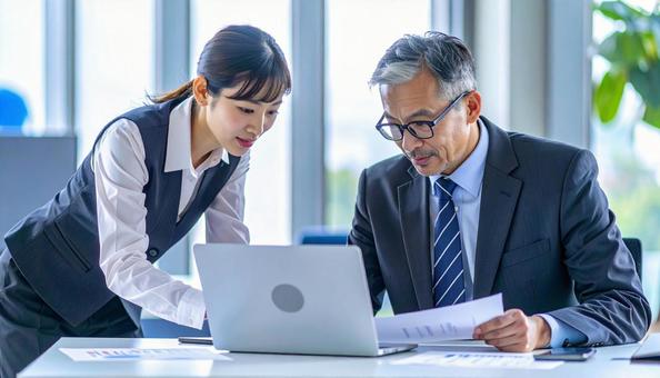 データを見ながら相談する上司と部下 データを見ながら相談する上司と部下の写真