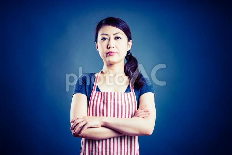 腕を組んで真剣な表情をする女性 1人,お母さん,まじめの写真素材
