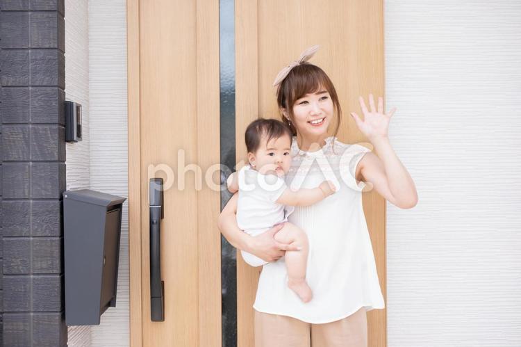 マイホームの前で赤ちゃんを抱く若い女性 親子,家族,赤ちゃんの写真素材