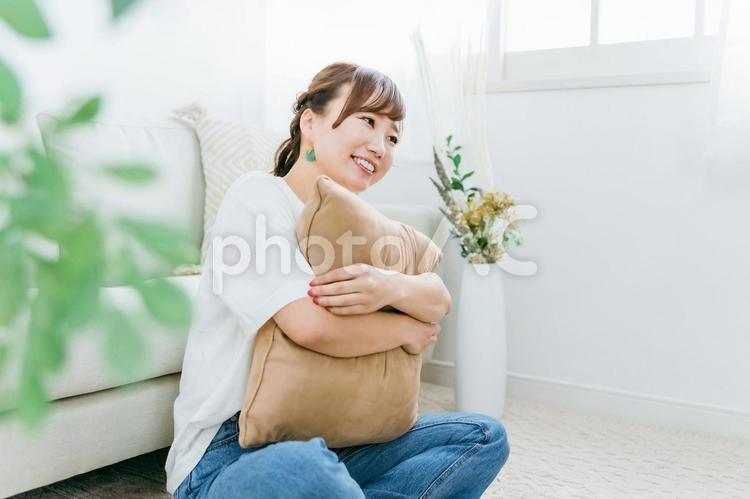 家でクッションを持つ笑顔のアジア人女性 女性,笑顔,笑うの写真素材