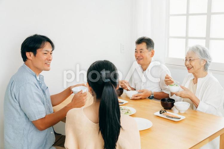 楽しい食事をする老夫婦と若い夫婦（笑顔） 家族,食事,里帰りの写真素材
