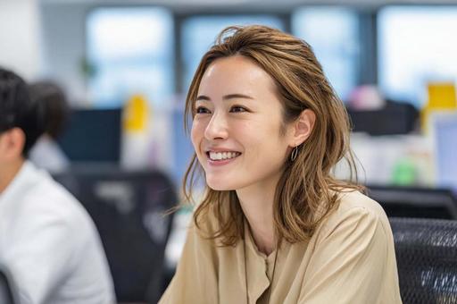 笑顔で会話するビジネス女性の写真