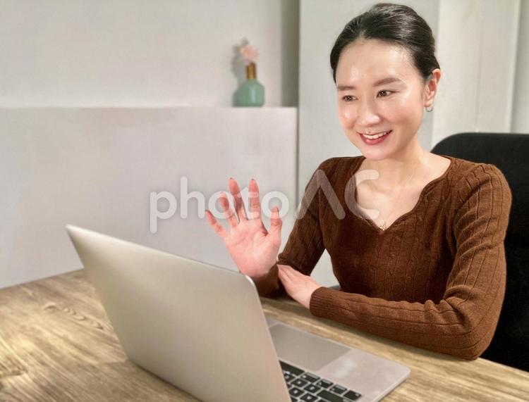 在宅勤務中にオンライン会議をする女性 女性,笑顔,パソコンの写真素材