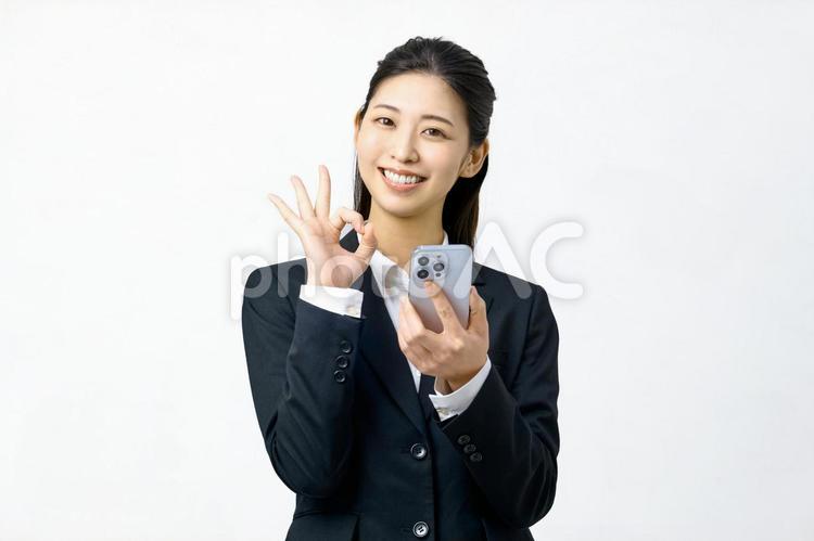 スマホを持つ　OKする若い女性　ビジネス スマホ,ビジネスウーマン,ビジネスの写真素材