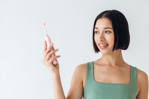遠くを見て電動歯ブラシを持つ女性 遠くを見て電動歯ブラシを持つ女性 女性,歯ブラシ,電動の写真素材