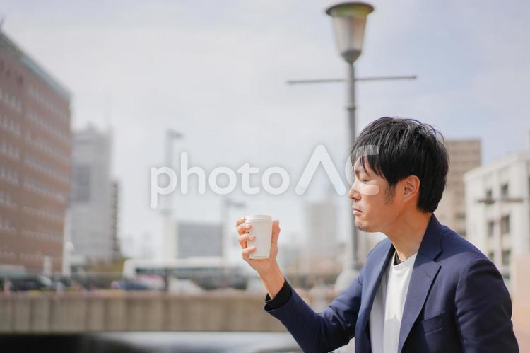 野外でコーヒーを飲む男性 ビジネス,考える,悩むの写真素材