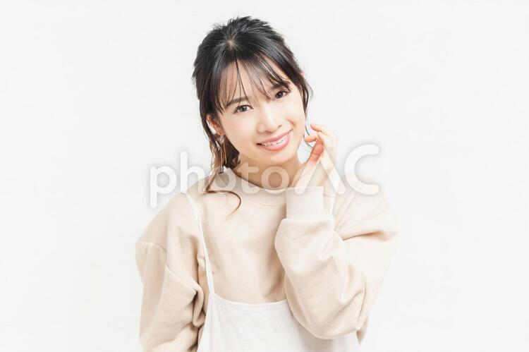 頬に手を当てる笑顔の若い女性 女性,頬,笑うの写真素材