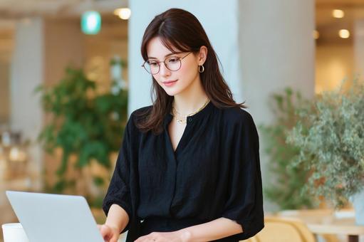 カフェでノートPCを使用して仕事中の女性 カフェでノートPCを使用して仕事中の女性の写真