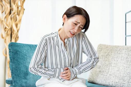 お腹を抑える女性 お腹を抑える女性 女性,体調不良,腹痛の写真素材