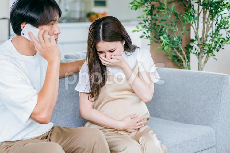 出産直前の妊婦の病院を探す男性（スマホ） 破水,陣痛,妊婦の写真素材