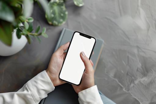 スマートフォンを操作する手元 スマートフォンを操作する手元の写真