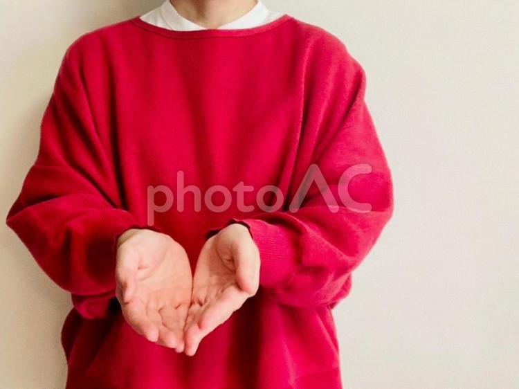 どうぞどうぞする赤い服を着た女性 どうぞ,あげる,女性の写真素材