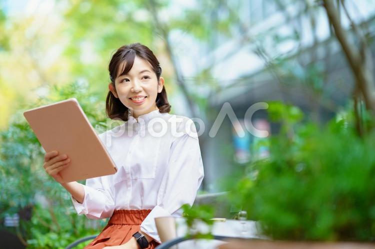 外で仕事をするオフィスカジュアル姿の女性  女性,ビジネス,清楚の写真素材