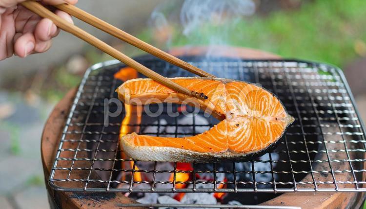 七輪で炭火焼する鮭の塩焼き 鮭,煙,箸の写真素材