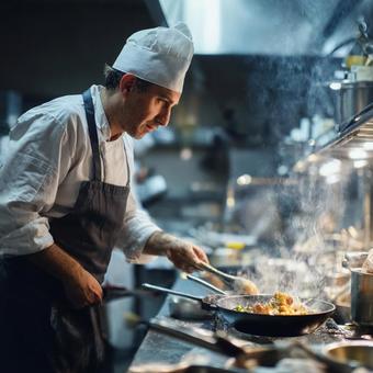 レストランの厨房で料理をするプロのシェフの写真