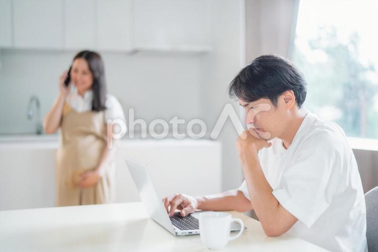 テレワークする男性と電話する妊婦（笑顔） 妊婦,妊娠,ママの写真素材