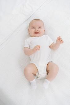 仰向けで笑う白い靴下の赤ちゃん 仰向けで笑う白い靴下の赤ちゃん 赤ちゃん,かわいい,仰向けの写真素材