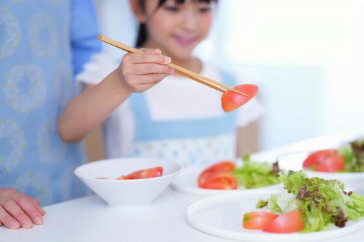トマトを盛り付ける食卓の風景 女の子,トマト,持つの写真素材