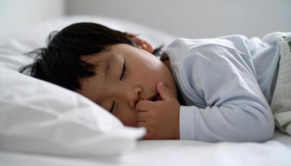 寝ながら指しゃぶりをする子供の横顔 寝ながら指しゃぶりをする子供の横顔の写真