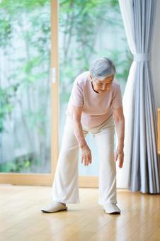 左足の方に両手を伸ばす高齢女性 女性,体操,手を伸ばすの写真素材