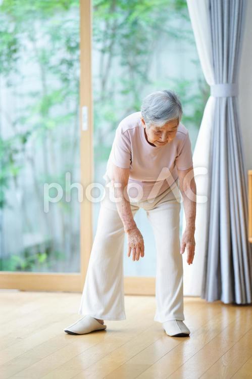 左足の方に両手を伸ばす高齢女性 女性,体操,手を伸ばすの写真素材