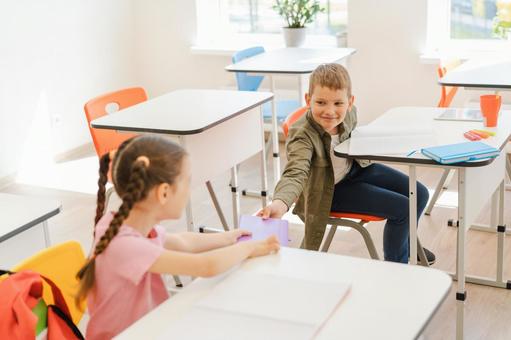 ノートを貸し借りする男の子と女の子 男の子,女の子,子どもの写真素材