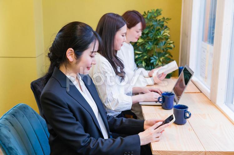 カフェの窓際カウンター席にいる女性（スマホを見る） スマホ,検索,アプリの写真素材