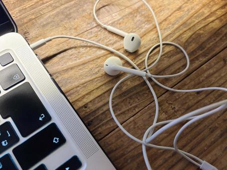 パソコンに繋がれた有線イヤホン イヤホン,有線,インナーイヤー型の写真素材