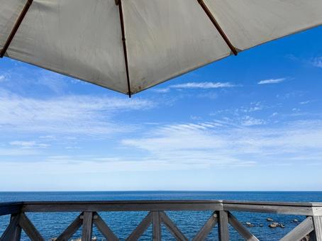 海辺のテラスで見上げるパラソルと青空 海辺,テラス,パラソルの写真素材