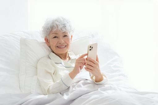 ベッドで寝ているシニア女性 ベッドで寝ているシニア女性 介護,シニア,女性の写真素材