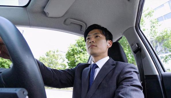 ワイヤレスイヤホンをつけて運転する男性 ワイヤレスイヤホンをつけて運転する男性の写真