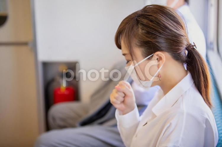 電車の中で咳をする女性 電車,咳,感染の写真素材