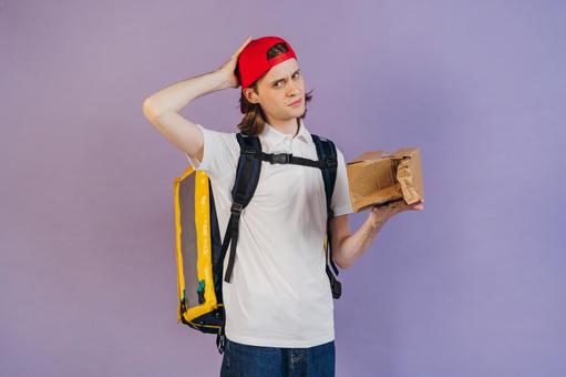 箱を潰してしまったフードデリバリーの男性の写真