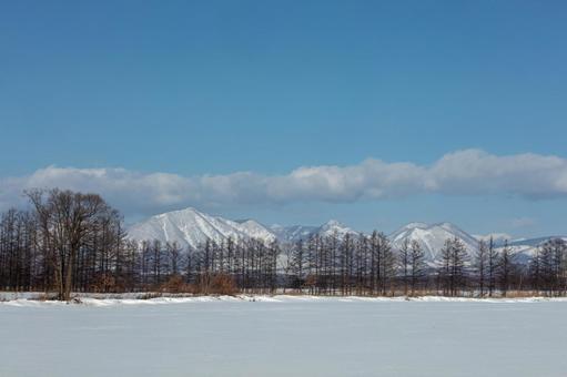然別の山並みと冬の牧場 然別の山並みと冬の牧場 雪原,青空,雪の写真素材