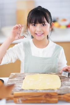 キッチンで型抜きを準備する子どもの笑顔 女の子,日本人,型抜きの写真素材