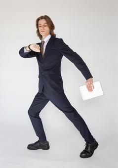 歩くポーズでスマートウォッチを見るスーツの男性 男性,外国人,欧米人の写真素材