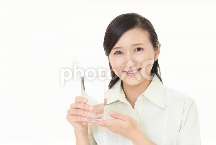 お水の入ったグラスを持つ笑顔の女性 女性,女,笑顔の写真素材
