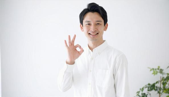 室内でOKサインをする笑顔の男性の写真