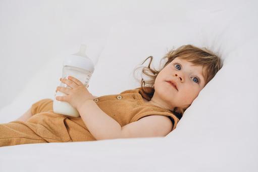 哺乳瓶を持つ子供 哺乳瓶を持つ子供 赤ちゃん,哺乳瓶,ミルクの写真素材