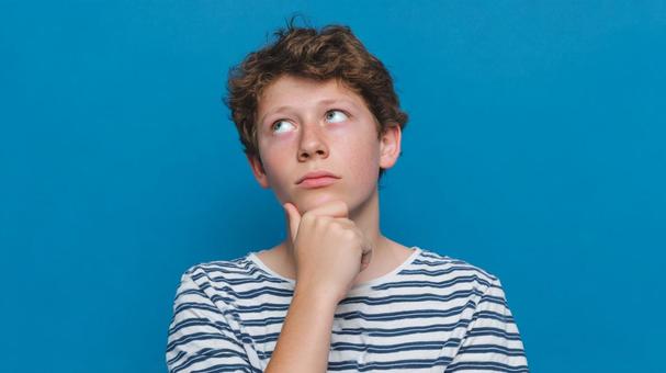 考え込むティーンエイジャーの男性 考え込むティーンエイジャーの男性の写真