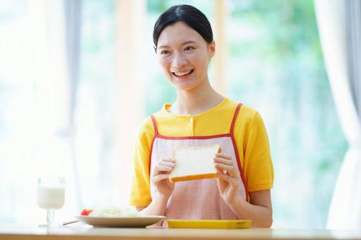 トーストを持ち笑う日本人女性 女性,トースト,食パンの写真素材