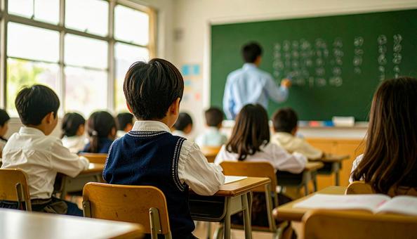 黒板に字を書く先生と授業を聞く生徒たちの写真