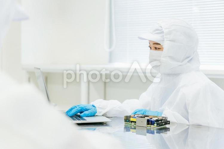 クリーンルームで精密機器を扱う女性 工場,製造業,精密機器の写真素材