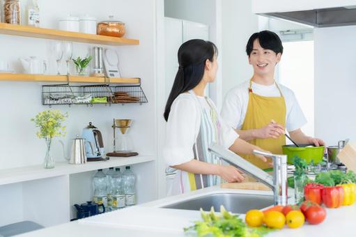 キッチンで料理を作る若い夫婦 キッチンで料理を作る若い夫婦 夫婦,料理,キッチンの写真素材