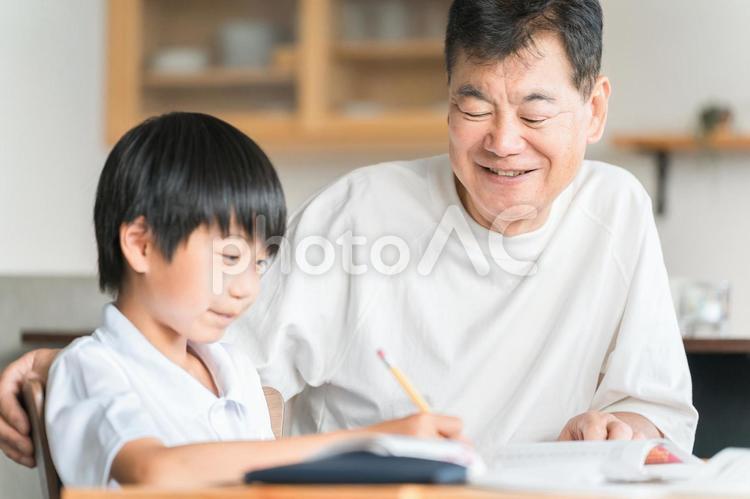 孫の宿題を教える高齢者男性と小学生の子供 宿題,子供,高齢者の写真素材