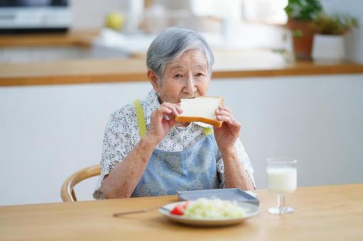 食パンを食べてい高齢女性 女性,食パン,食べるの写真素材
