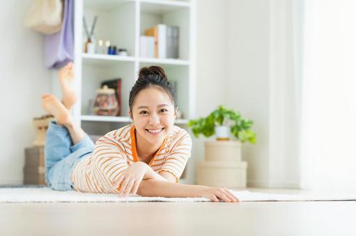 リビングでくつろぐ若い女性 リビングでくつろぐ若い女性の写真